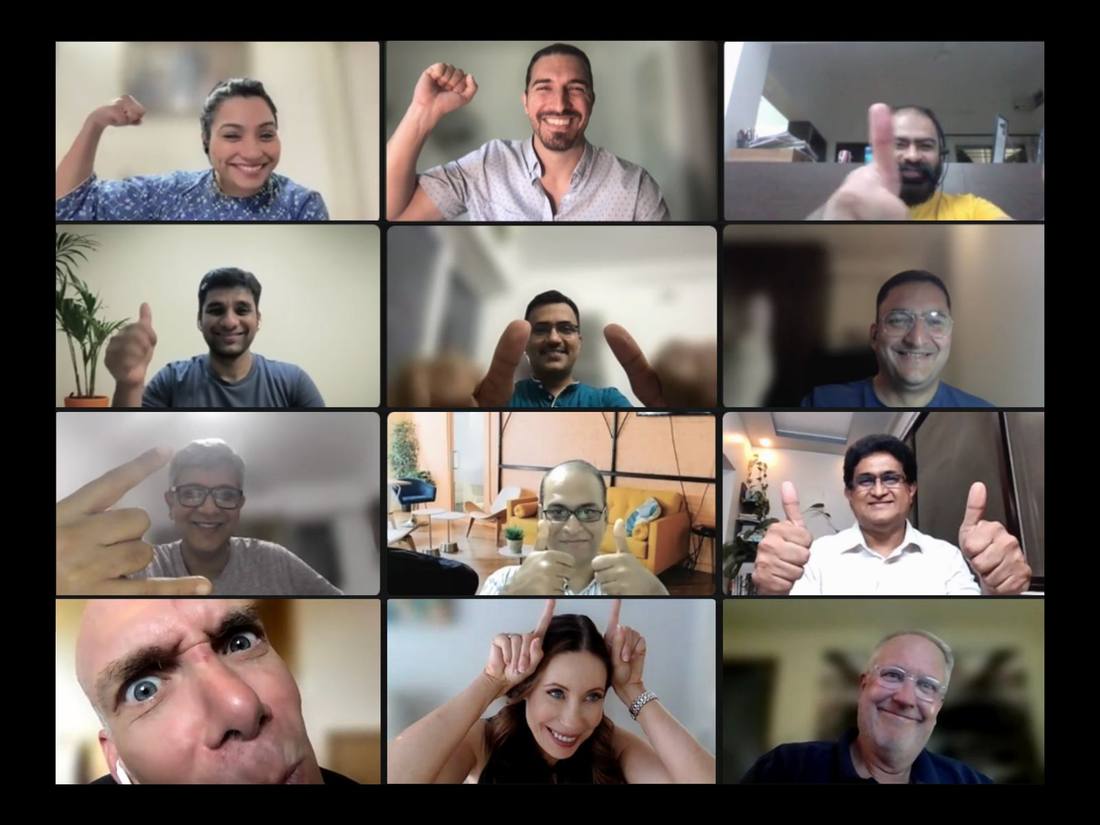 A grid of faces on a video call, arms raised, thumbs up