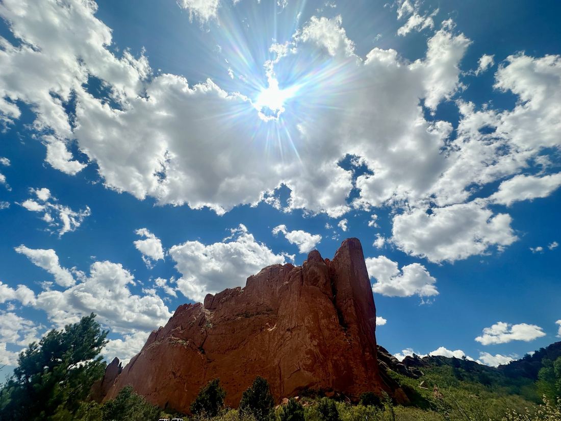 A red rock fin at Garden of the Gods under a bright sky and scattered cloud