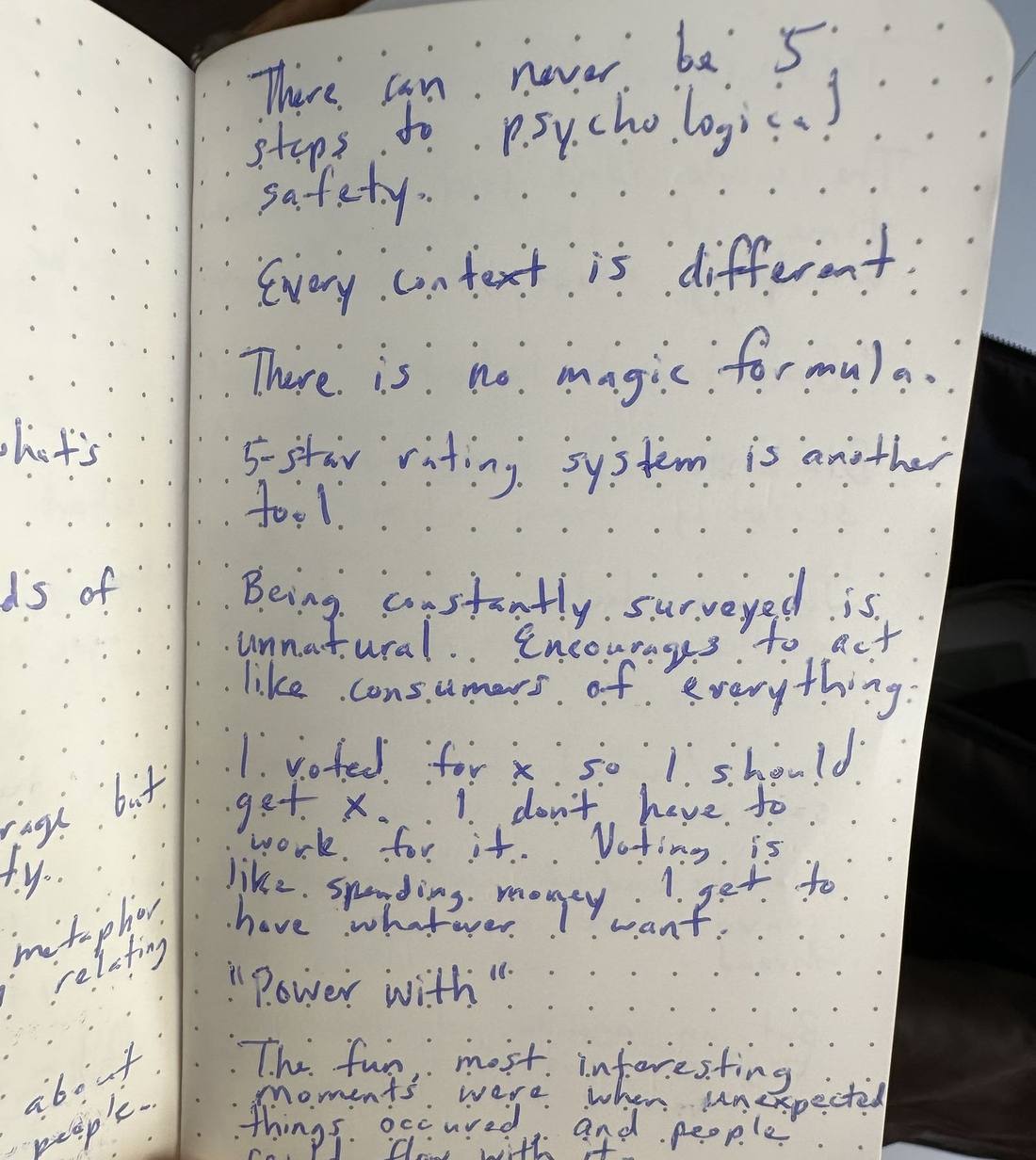 An open dotted notebook page covered in handwritten blue ink