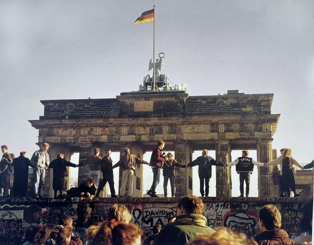 Crowds joined hand to hand on the Berlin Wall before the Brandenburg Gate, 1989