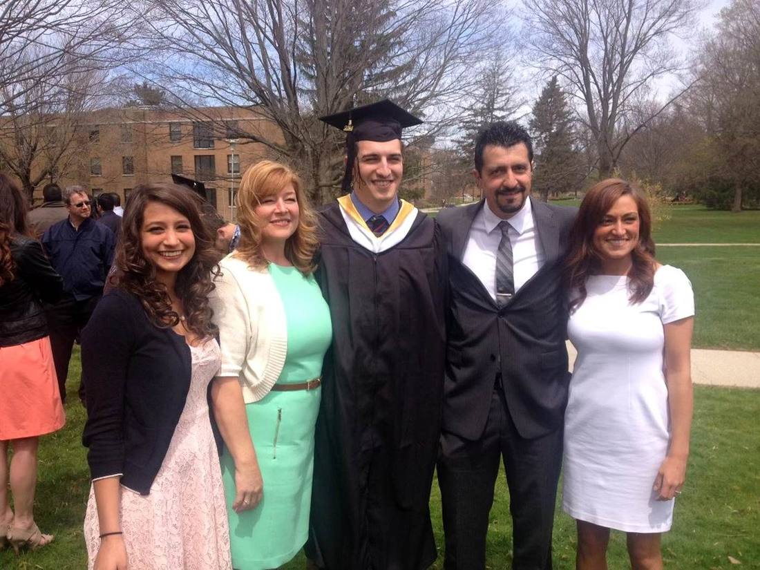 Family gathered on a lawn at graduation, cap and gown