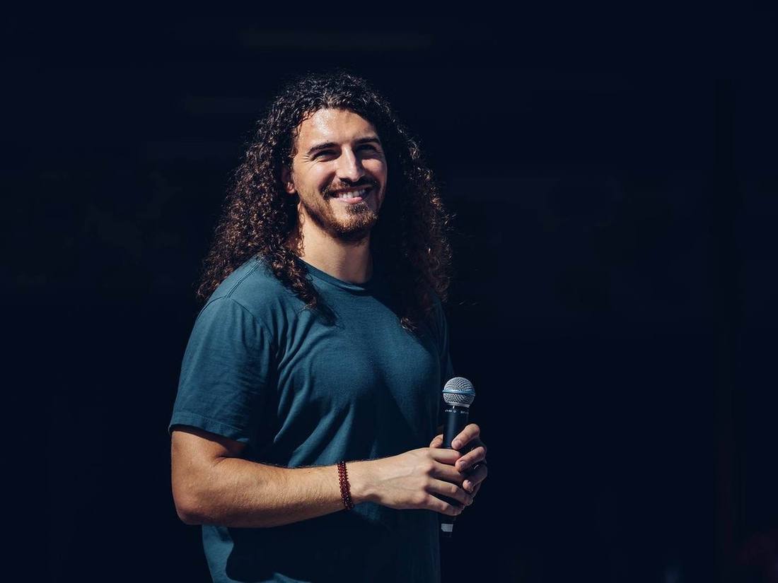 Holding a microphone on a darkened stage
