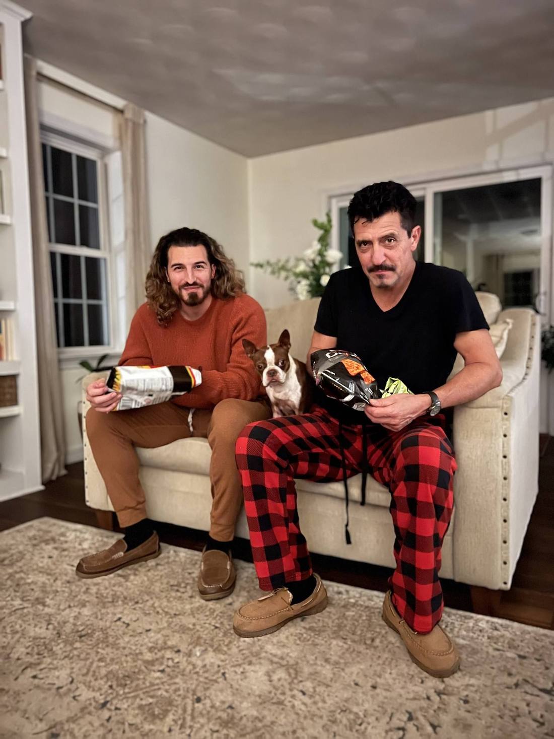 My father and I on a couch with the dog between us, a bag of chips each