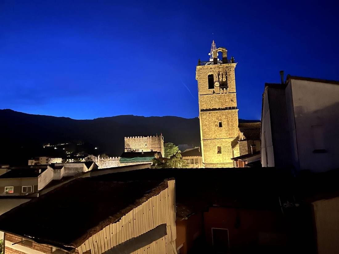 The cathedral tower and castle of Arenas de San Pedro against a deep blue night