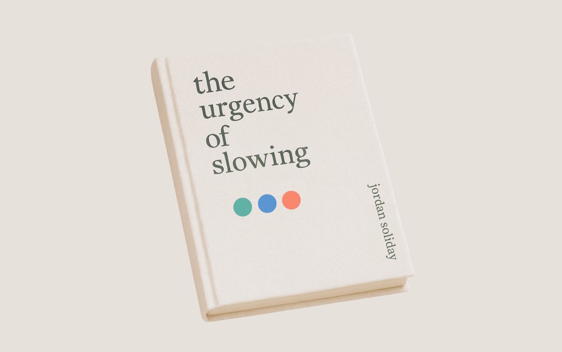 The cover of The Urgency of Slowing, cloth bound, three coloured dots beneath the title